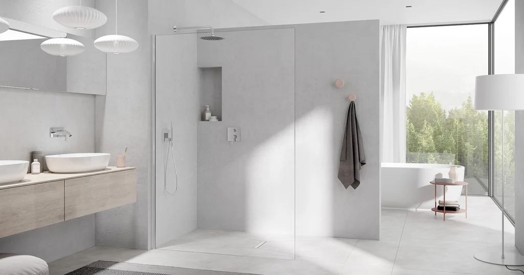 Modern bathroom with a minimalist design featuring a glass shower, double sinks on a wooden vanity, and a freestanding tub by a large window overlooking trees.