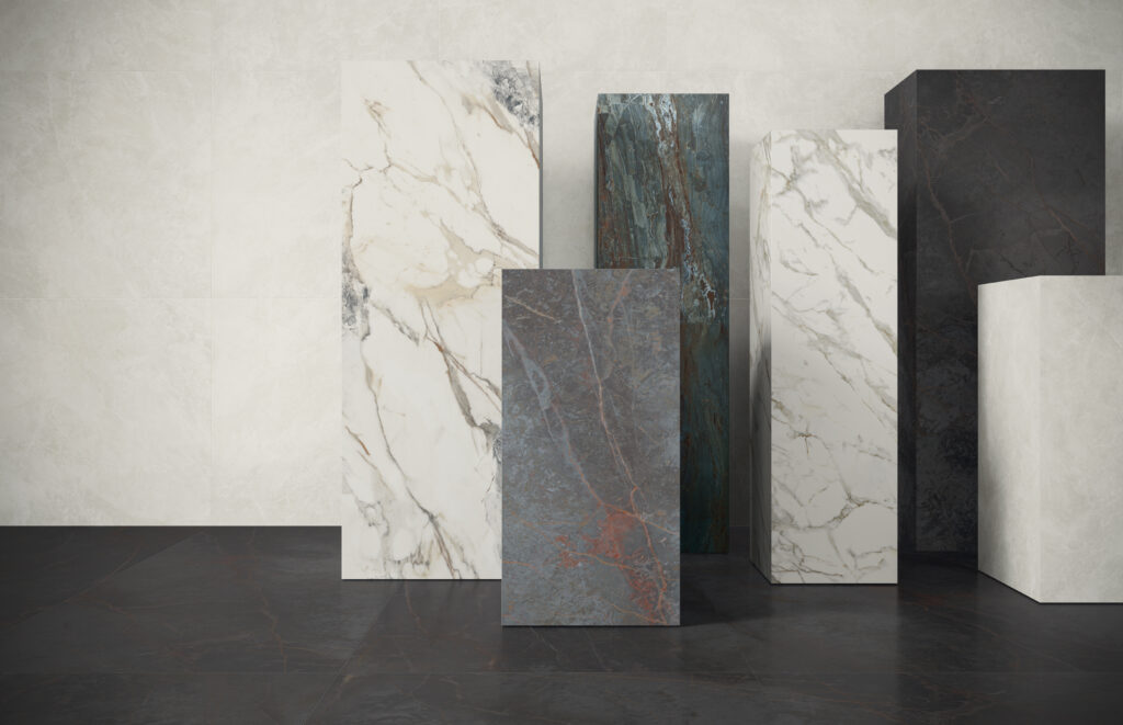 Tall rectangular slabs with various stone textures are arranged in a row. Patterns include white marble, dark stone, and mixed-colored minerals, conveying elegance.
