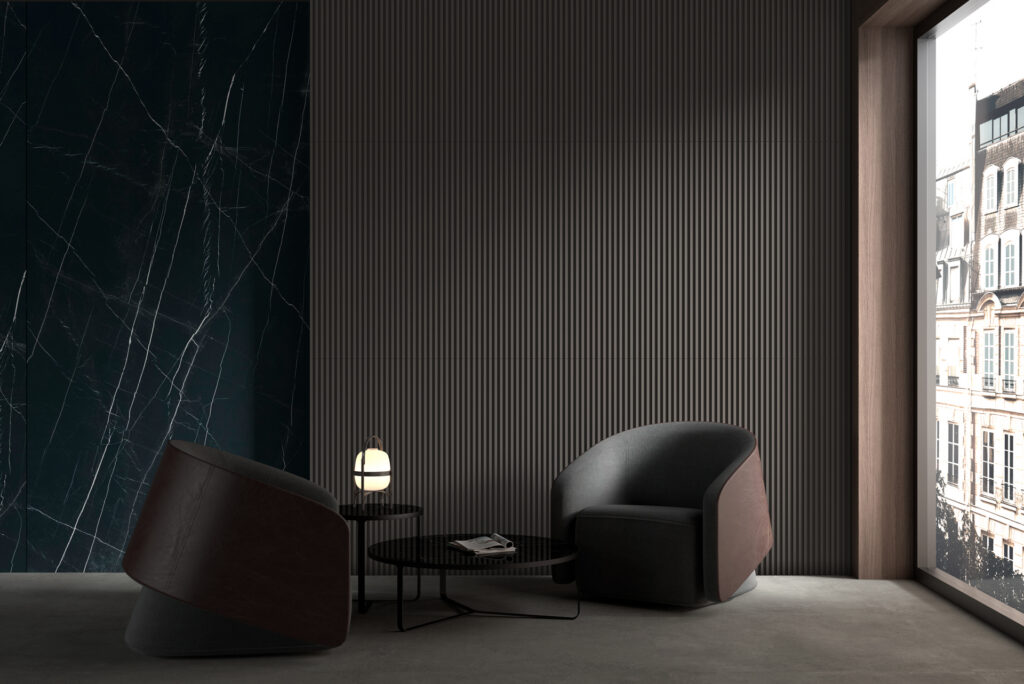 Modern interior with two rounded armchairs, a glass coffee table, and a marble wall, featuring a cityscape view from a large window.