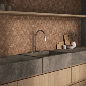 Kitchen backsplash featuring a dark stone countertop paired with triangle mosaic wood-look wall tiles from the Portobello Arca Tropical collection.